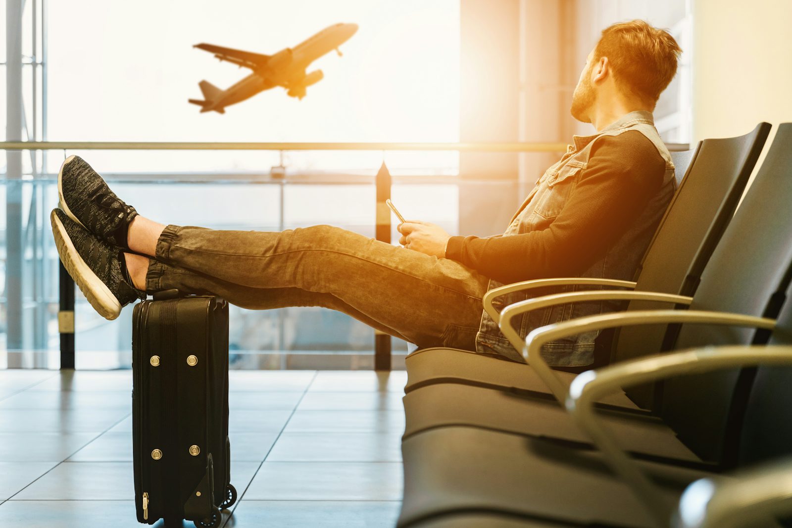 Voyageur patientant face à un avion au coucher du soleil
